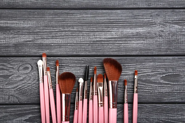 Set van make-up borstels op grijze houten tafel — Stockfoto