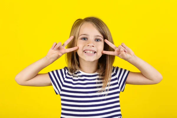 Красива маленька дівчинка на жовтому тлі — стокове фото