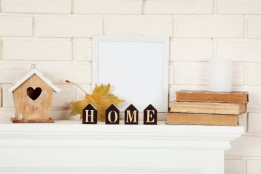 Yuvalama kutusu, eski kitaplar ve fotoğraf çerçevesi ile beyaz şömine