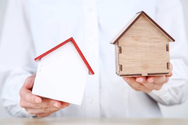 Ahşap ev modelleri tutan kadın elleri