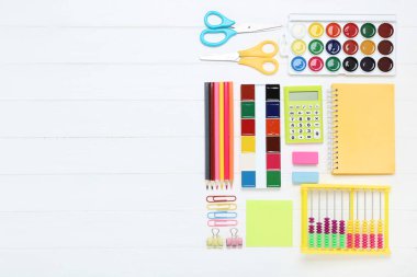 Okul malzemeleri beyaz ahşap masada.