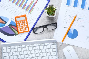 Klavye, fare, gözlük ve hesap makinesi ile finansal kağıtlar