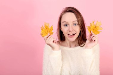 Pembe arka plan üzerinde kuru yapraklı genç kız