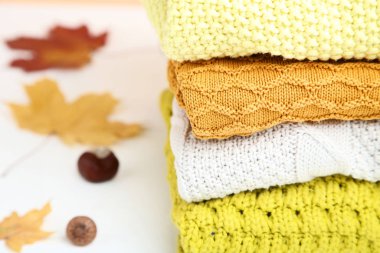 Sonbahar yaprakları ve kestane ile katlanmış kazak Yığını