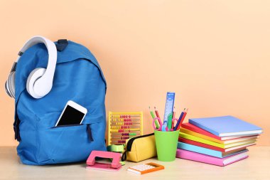 Bej arka planda okul malzemeleri ile Sırt Çantası