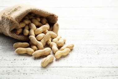 Beyaz ahşap masa üzerinde çuval bezi fıstık