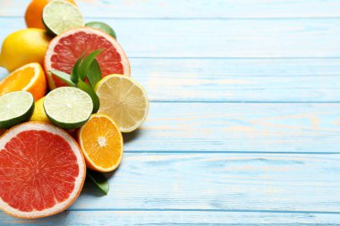 Mavi ahşap masada yeşil yapraklı narenciye