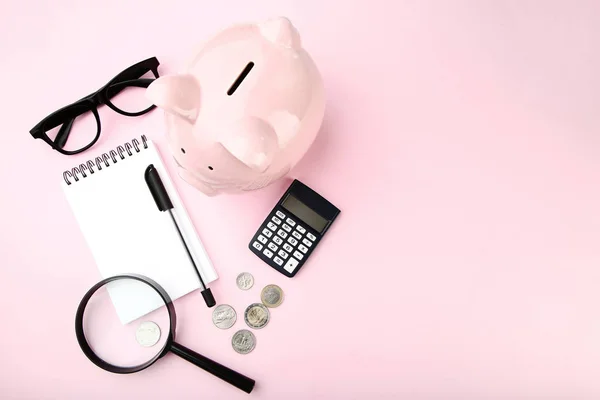 Piggy bank rosa com notebook, moedas e lupa no pino — Fotografia de Stock