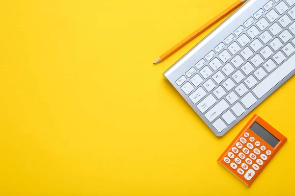 Clavier d'ordinateur avec calculatrice et crayon sur fond jaune — Photo