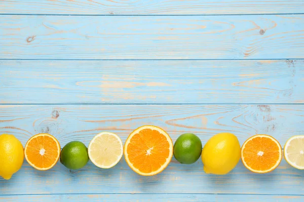 Citrusové plody na modrém dřevěném stole — Stock fotografie