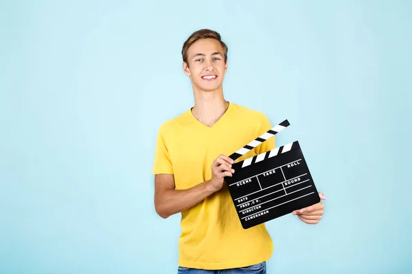 Ung mand med clapper bord på blå baggrund - Stock-foto