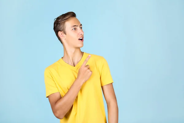 파란색 배경에 노란색 티셔츠를 입은 청년의 초상화 — 스톡 사진