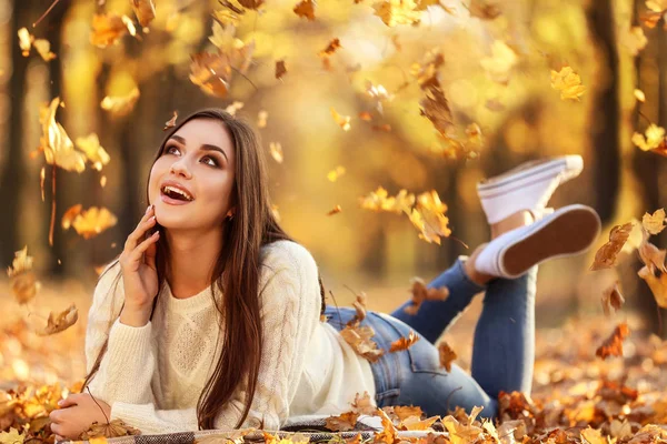 Mooie vrouw liggend op de grond in herfst park — Stockfoto