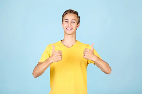 Portret van de jonge man in geel t-shirt op blauwe achtergrond — Stockfoto