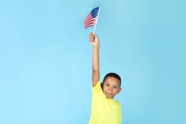 Mavi arka planda Amerikan bayrağı ile sevimli çocuk