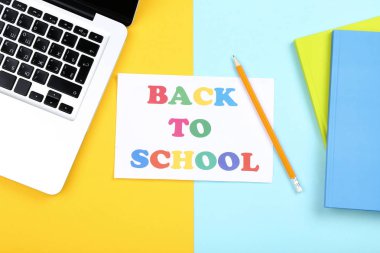 Renkli backgro dizüstü bilgisayar ve not defterleri ile Okula Metin Geri