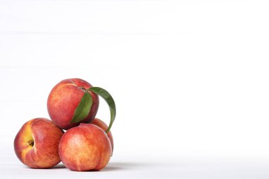 Beyaz arka planda yeşil yapraklı taze şeftali