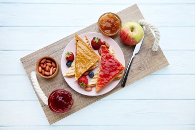 Beyaz ahşap t fıstık ezmesi, reçel, meyve ve fındık ile Ekmek