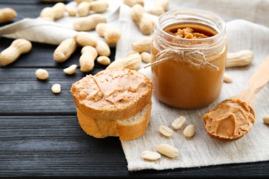 Siyah ahşap masada ekmek ve fındık ile fıstık ezmesi