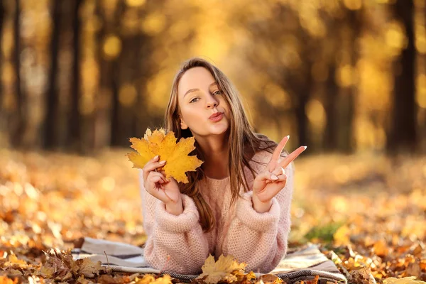 Młoda piękna dziewczyna leżąca z klonami liści w jesiennym parku — Zdjęcie stockowe