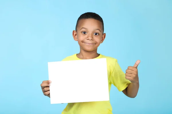Süßer amerikanischer Junge mit leerem Brett auf blauem Hintergrund — Stockfoto