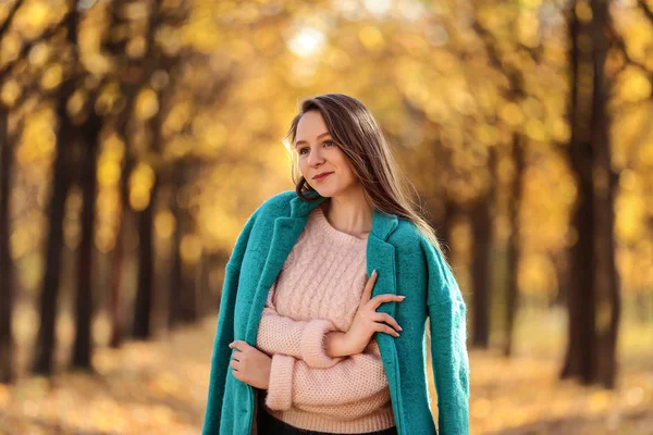 Jong mooi meisje met groene vacht in herfst Park — Stockfoto