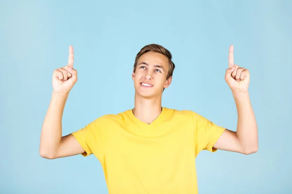 Porträtt av ung man i gul t-shirt på blå bakgrund — Stockfoto