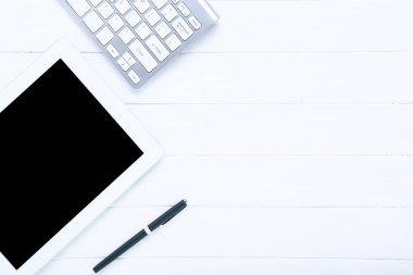 Beyaz ahşap masa üzerinde kalem ile tablet ve bilgisayar klavyesi