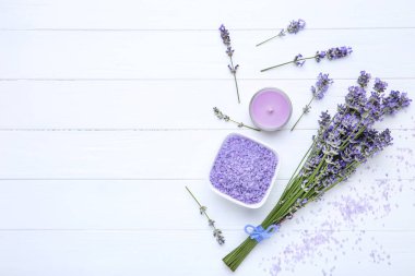 Beyaz ahşap masada spa tuzu ve mum ile Lavanta çiçekleri