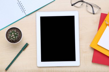 Kahverengi ahşap masa üzerinde ofis malzemeleri ile Tablet bilgisayar
