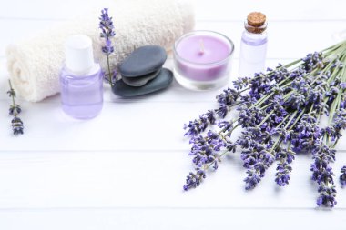 W üzerinde şişe, mum ve spa taşları yağ ile Lavanta çiçekleri