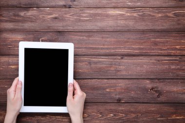 Kahverengi ahşap masa üzerinde kadın ellerde Tablet bilgisayar
