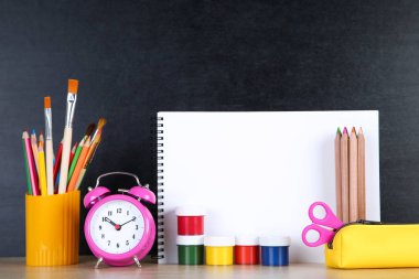 Kara tahta backgrou üzerinde kağıt boş levha ile Okul malzemeleri