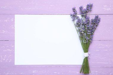 Mor ahşap tabl üzerinde kağıt boş levha ile Lavanta çiçekleri