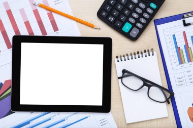 Tablet bilgisayar ve ahşap masa üzerinde grafik ve grafikler ile kağıtları