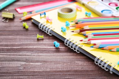 Okul malzemeleri kahverengi ahşap masada.