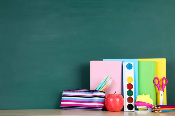 Material escolar con manzana roja sobre fondo verde —  Fotos de Stock