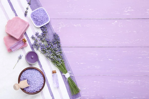 Lavender flowers with oil, soap and salt on puple wooden table — Stock Photo, Image