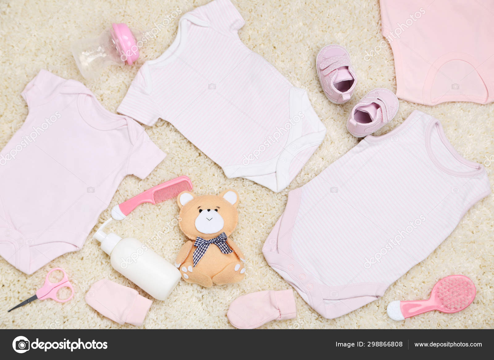 Roupas com brinquedos e suprimentos para bebês no tapete — Foto