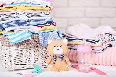 Yumuşak ayı oyuncağı ve bebek malzemeleri ile katlanmış giysiler.