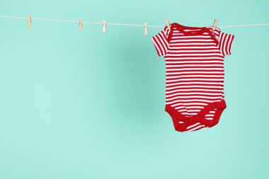 Mavi arka planda asılı bebek kıyafetleri