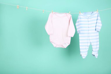 Mavi arka planda asılı bebek kıyafetleri