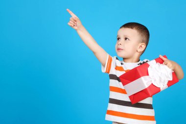 Mavi arka plan üzerinde hediye kutusu ile sevimli küçük çocuk