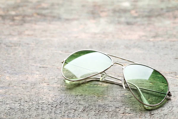 Fashion sunglasses on grey wooden table — Stock Photo, Image