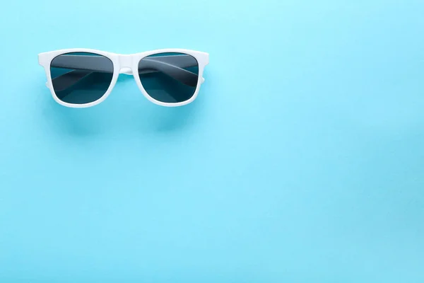Modern sunglasses on blue background — Stock Photo, Image
