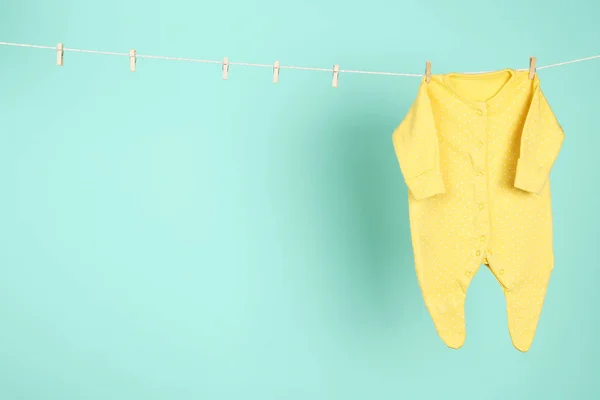 Mavi arka planda asılı bebek kıyafetleri — Stok fotoğraf