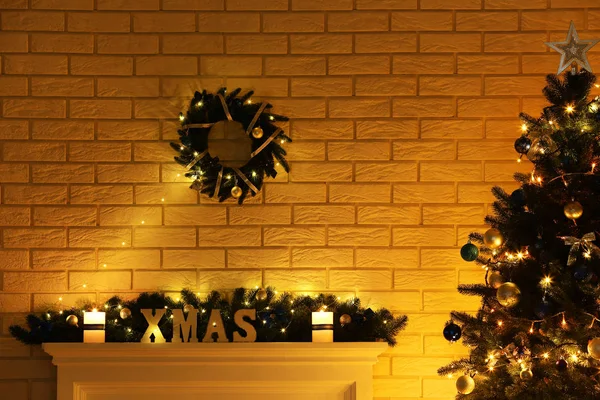 Caminetto bianco decorato vicino albero di Natale sul muro di mattoni indietro — Foto Stock