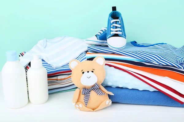 Folded clothes with soft bear toy and baby supplies