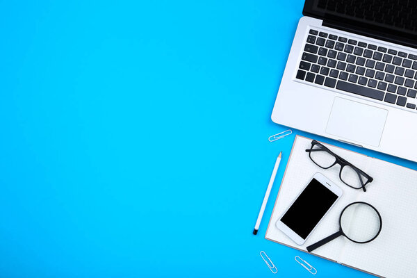Ordenador portátil con smartphone, gafas y bloc de notas en azul bac — Foto de Stock