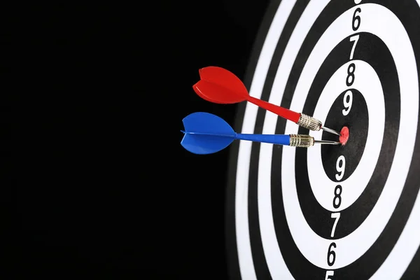 Dartboard with darts on black background — Stock Photo, Image